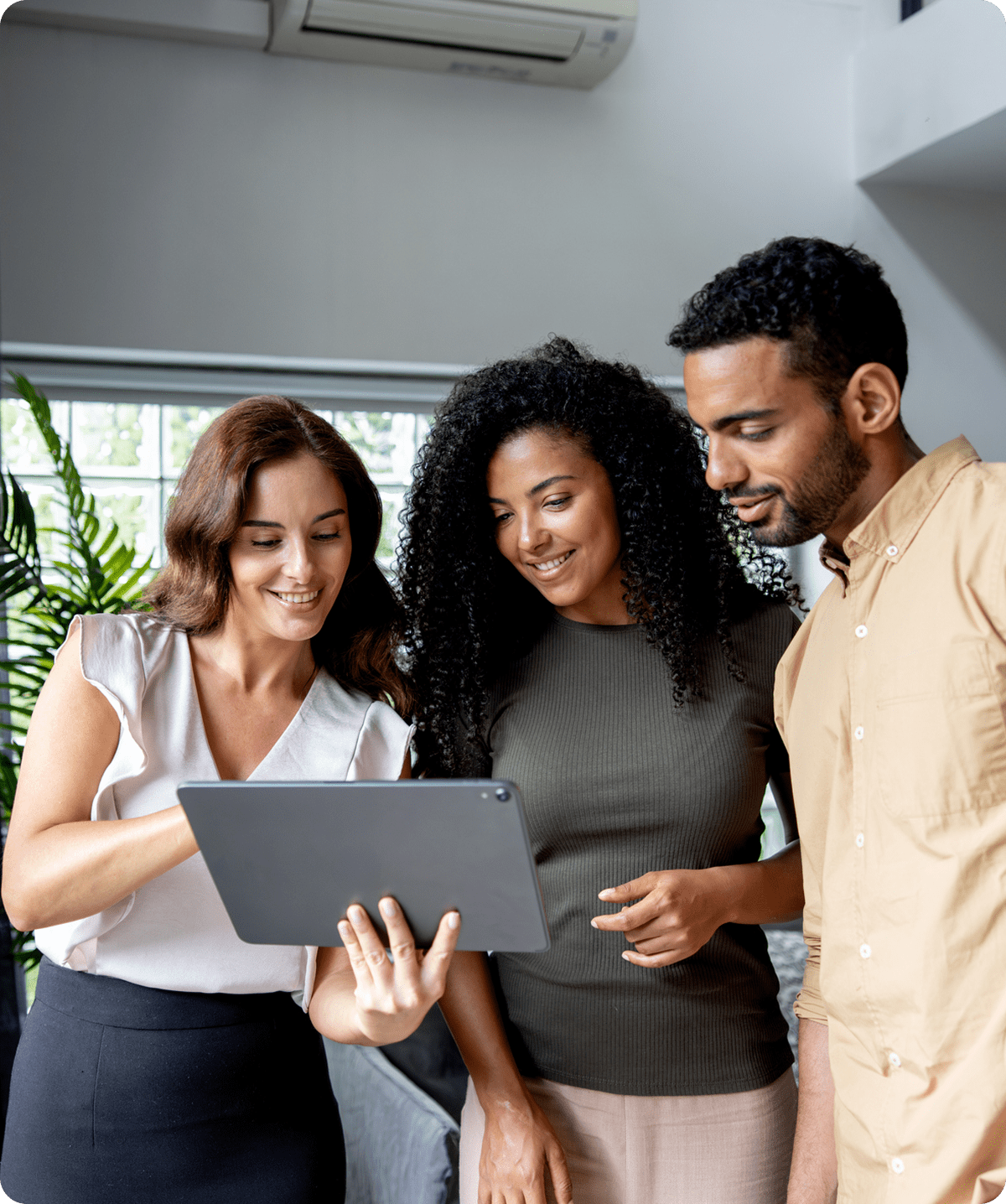 Three people looking at a tablet.