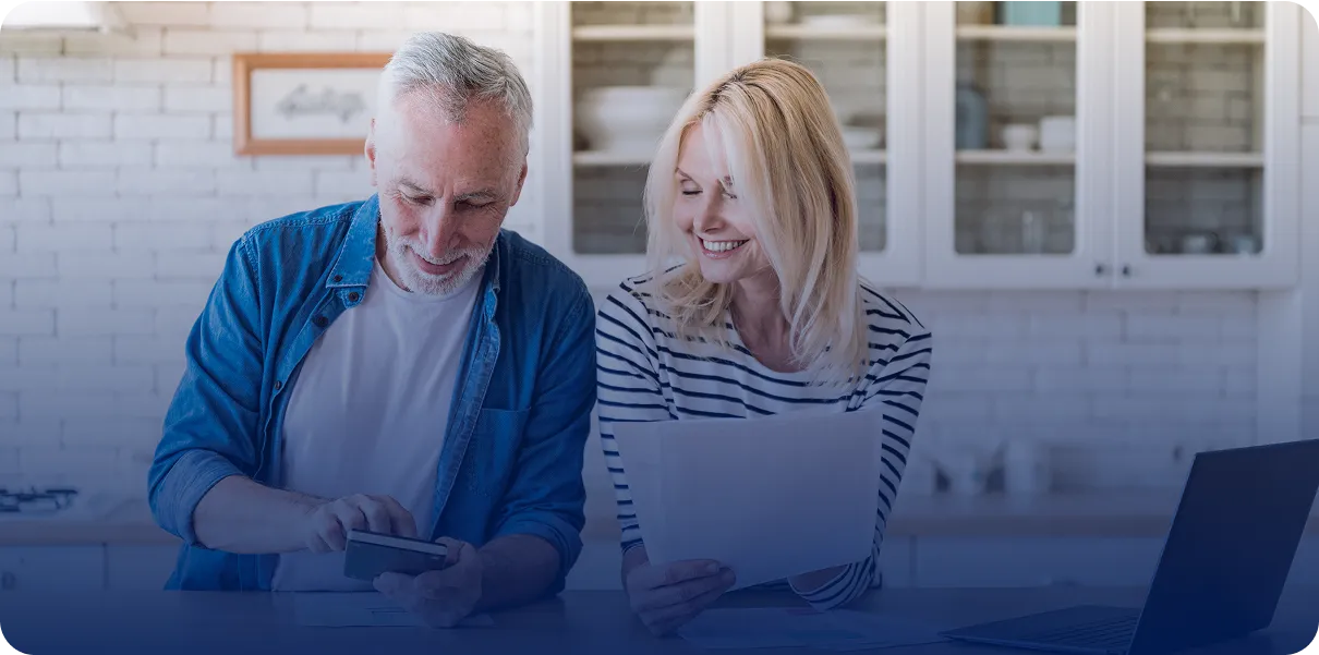 Older couple looking at phone and papers.