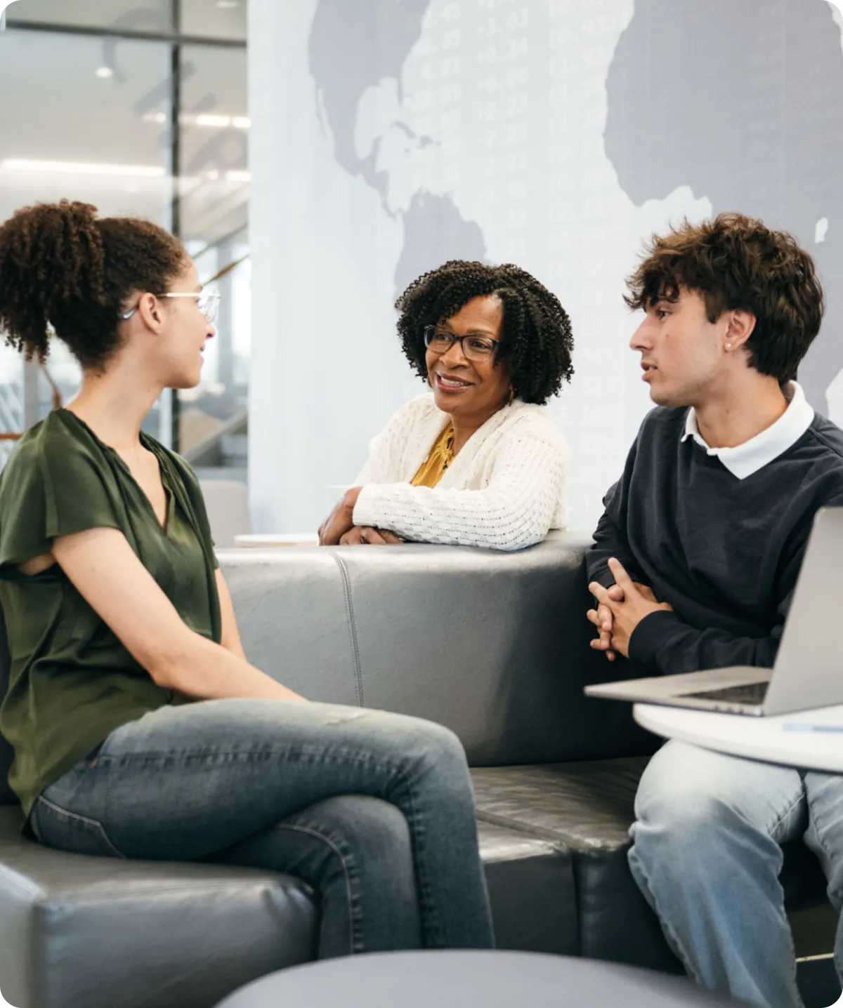 Three people having a conversation on couch.